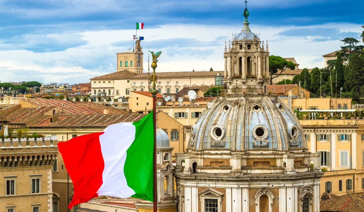 Country & Location: Italy, Rome, Italian cityscape
Landmarks: Historic architecture, dome, church, Quirinal Palace (Palazzo del Quirinale)
Weather & Season: December, winter, cloudy sky
Culture & Symbols: Italian flag, national pride, European heritage
Photography Style: Travel photography, urban landscape, historic scenery